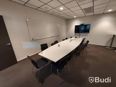 Konferensrum med bord, stolar, tv skärm