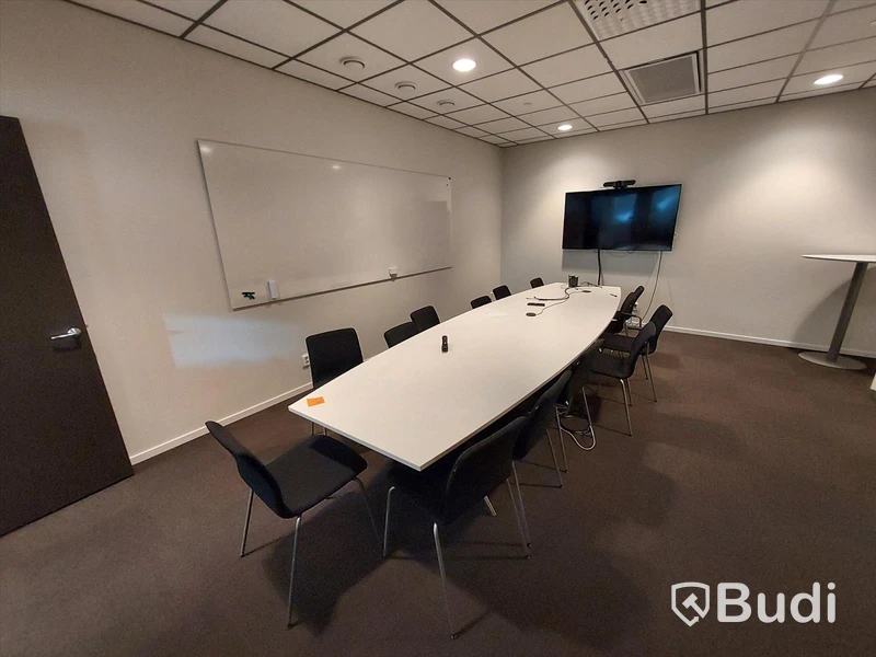 Konferensrum med bord, stolar, tv skärm