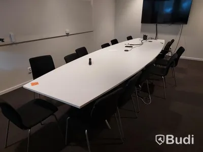 Konferensrum med bord, stolar, tv skärm