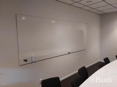 Konferensrum med bord, stolar, tv skärm