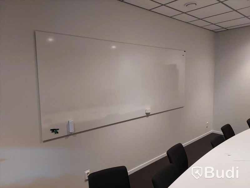 Konferensrum med bord, stolar, tv skärm