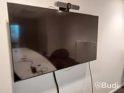 Konferensrum med bord, stolar, tv skärm