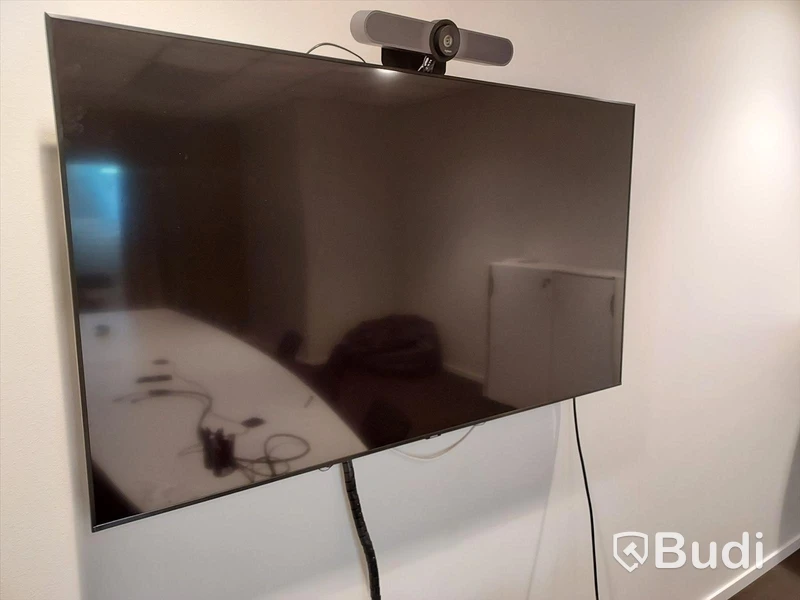 Konferensrum med bord, stolar, tv skärm