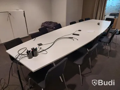 Konferensrum med bord, stolar, tv skärm