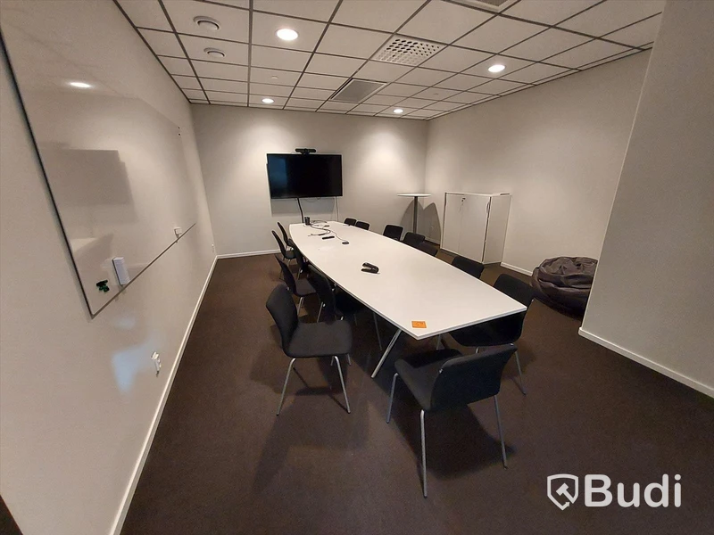 Konferensrum med bord, stolar, tv skärm