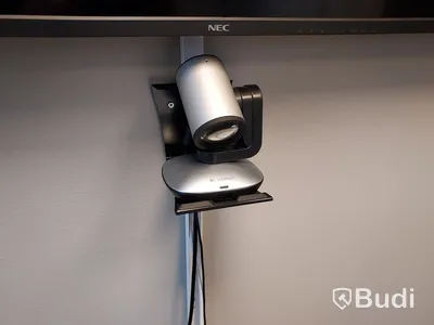 Konferensrum med tv-skärm, samt kamera/högtalare, bord och stolar