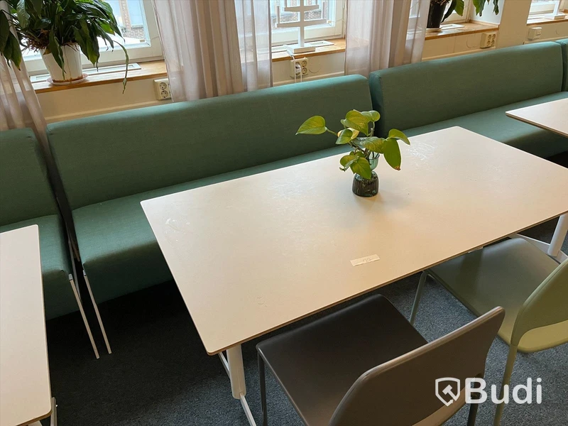 Rektangulärt vitt bord med två stolar och en soffa