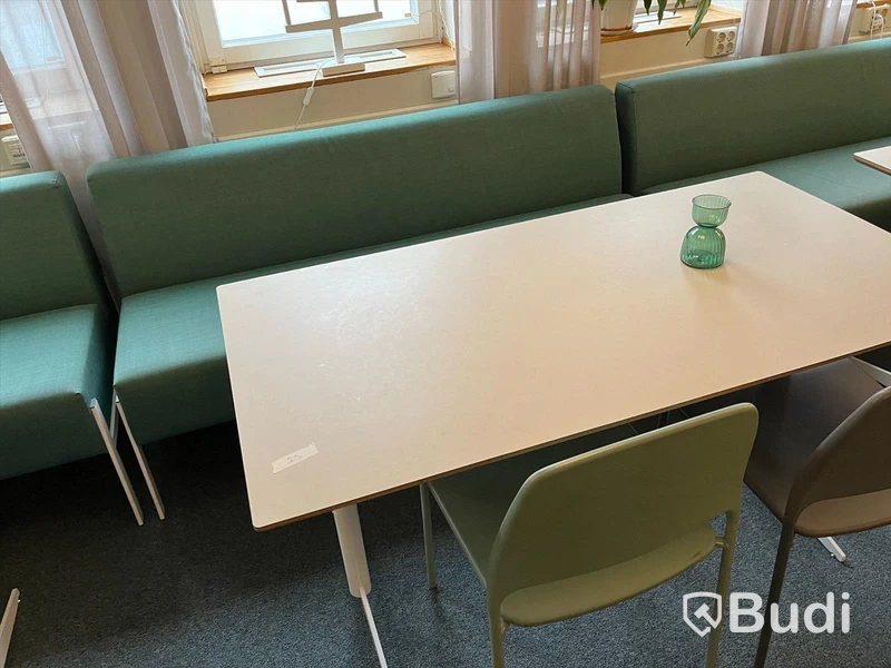 Rektangulärt vitt bord med två stolar och en soffa