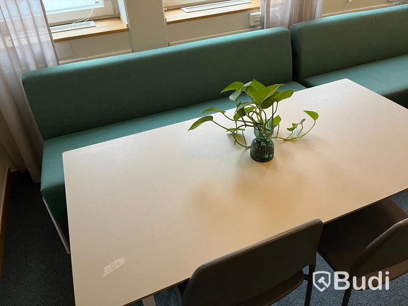 Rektangulärt vitt bord med två stolar och en soffa
