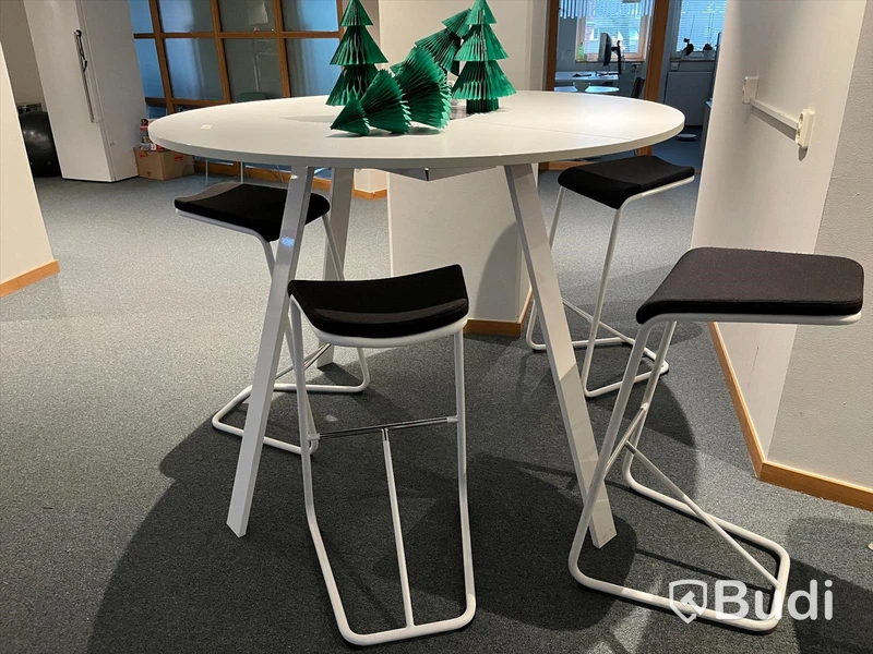 Runt vitt högre bord med barstolar