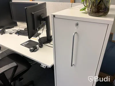 2 st arbetsplatser, vitt skrivbord, vita dragskjutskåp, datorskärmar, stolar
