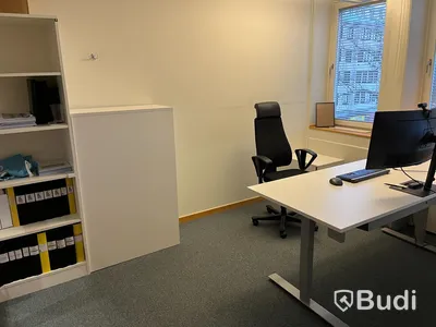 Kontorsarbetsplats, höj- & sänkbart skrivbord, stol, datorskärm, bokhylla, besöksbord med stolar