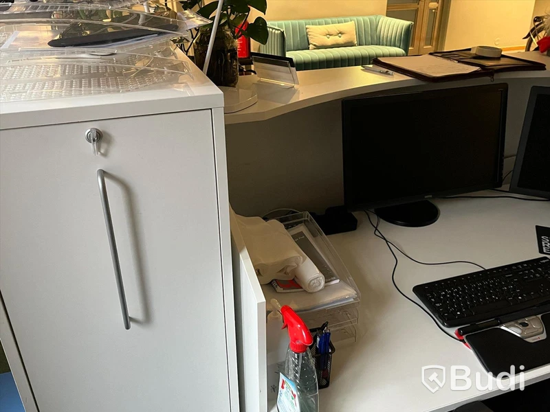 Receptionsdisk/ Kontorsplats, vitt skrivbord, stol, datorskärm, dragskjutskåp