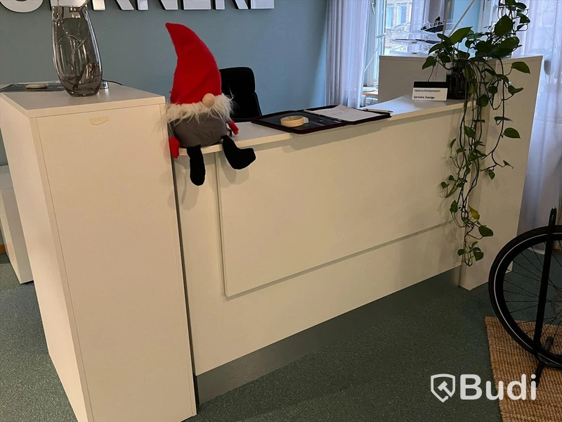 Receptionsdisk/ Kontorsplats, vitt skrivbord, stol, datorskärm, dragskjutskåp