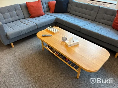 Loungegrupp med soffa, soffbord, pallar, tavellister, tavlor, växt