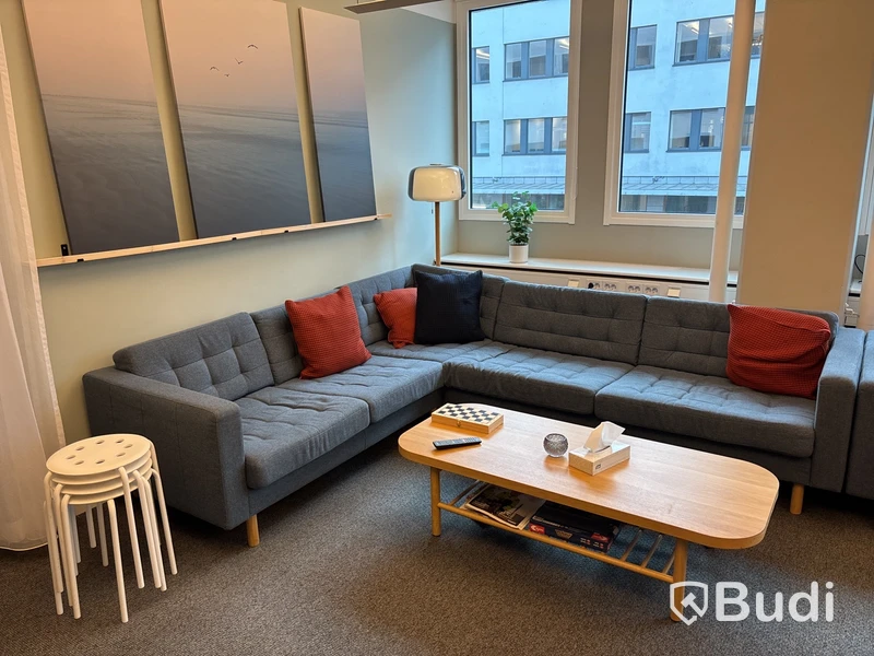 Loungegrupp med soffa, soffbord, pallar, tavellister, tavlor, växt