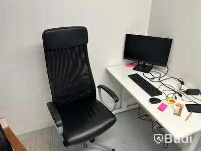 Höj- och sänkbart skrivbord med kontorsstol, datorskärm, tangentbord och datormus