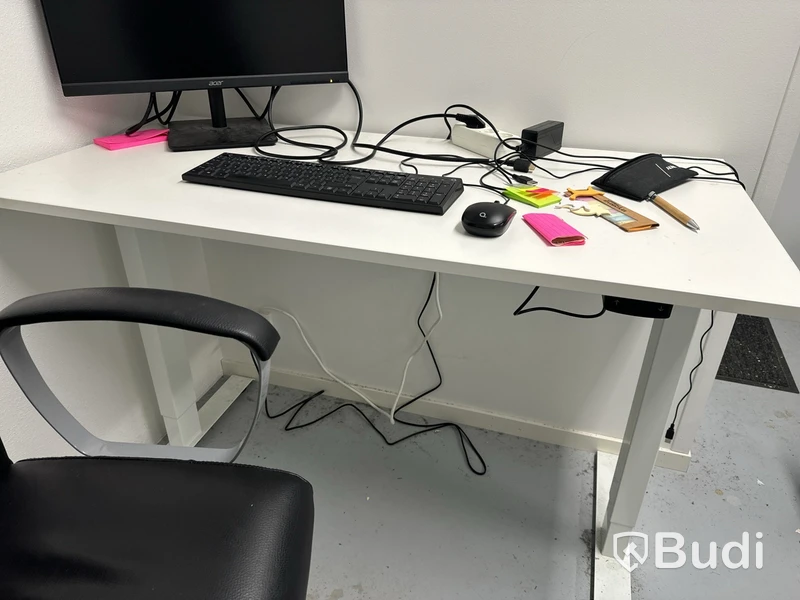 Höj- och sänkbart skrivbord med kontorsstol, datorskärm, tangentbord och datormus