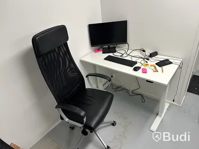 Höj- och sänkbart skrivbord med kontorsstol, datorskärm, tangentbord och datormus
