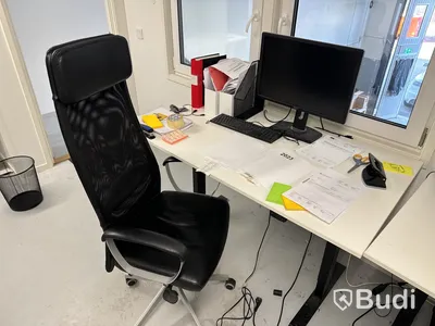 Höj- och sänkbart skrivbord med kontorsstol, datorskärm och tangentbord
