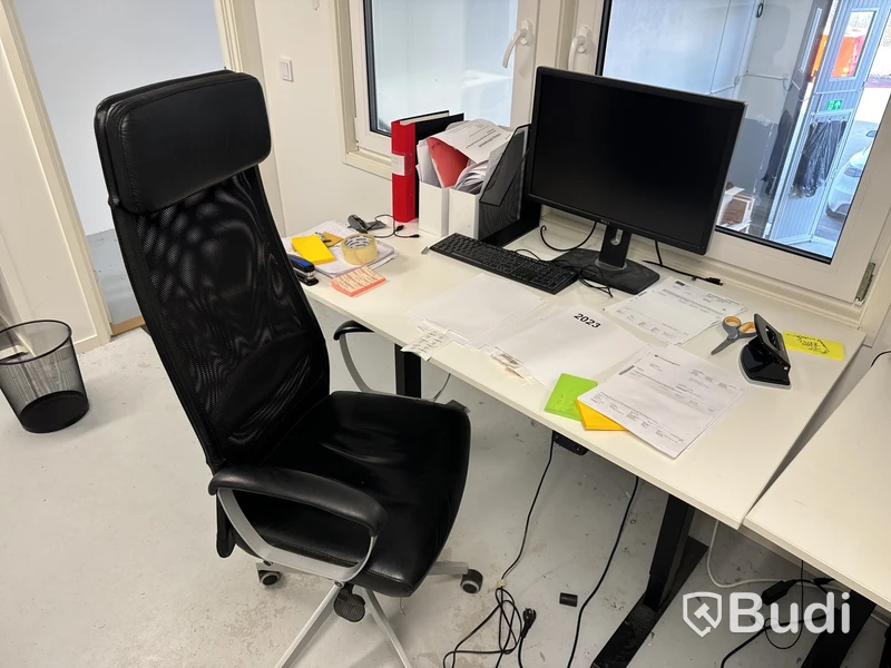 Höj- och sänkbart skrivbord med kontorsstol, datorskärm och tangentbord
