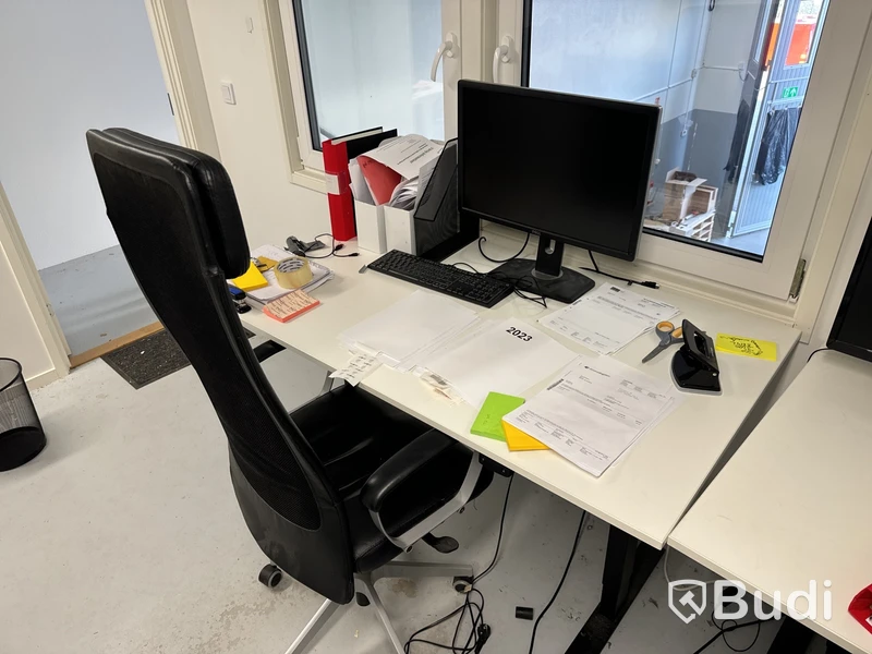 Höj- och sänkbart skrivbord med kontorsstol, datorskärm och tangentbord
