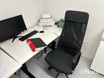 Höj- och sänkbart skrivbord med kontorsstol, datorskärm, tangentbord och datormus