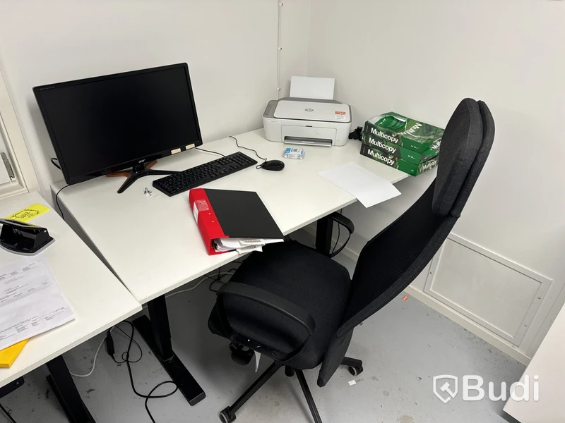 Höj- och sänkbart skrivbord med kontorsstol, datorskärm, tangentbord och datormus