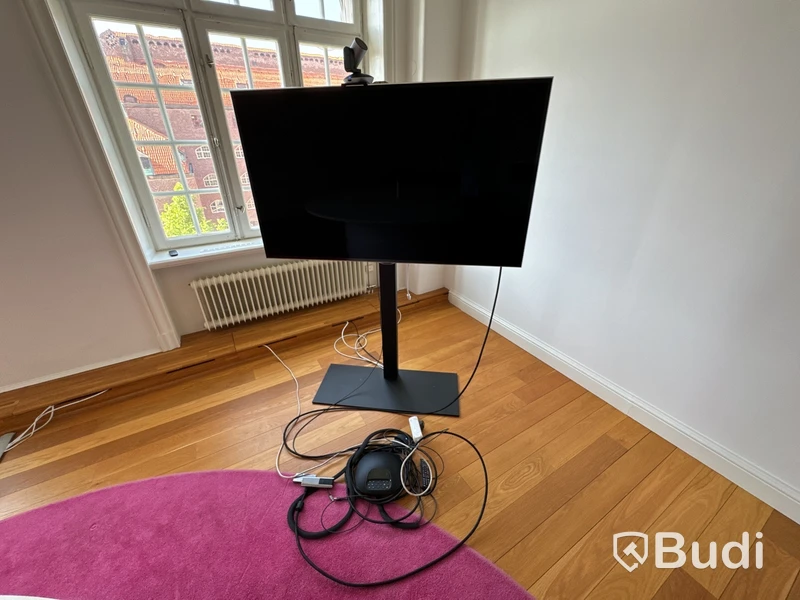 Samsung-TV på stativ med tillhörande konferensutrustning