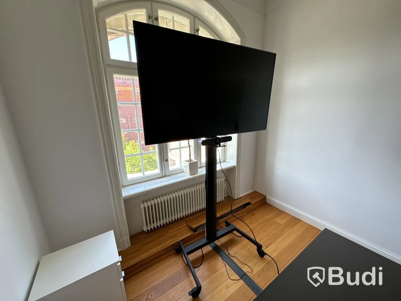 Samsung-TV på stativ med tillhörande konferensutrrustning