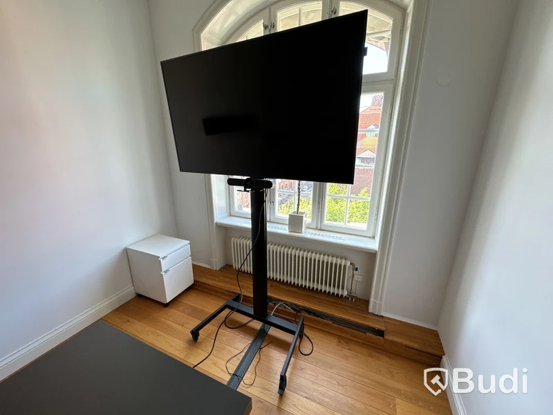 Samsung-TV på stativ med tillhörande konferensutrrustning