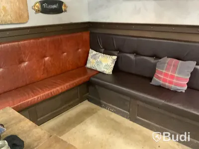 Platsbyggd U-soffa med skinndynor, 660cm lång, 230 djup på djupaste punkten samt kuddar.