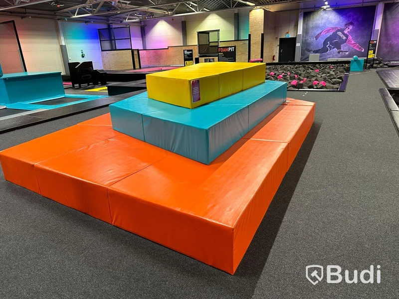 Relax Area – orange/blå/gul-färgade sittbänkar i tre höjder på varandra samt 4 st orange sittbänkar