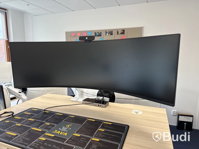 Samsung 49 tum curved datorskärm med bordfäste USB-docka samt logitech kamera. Skärmen är C49G95TSSR
