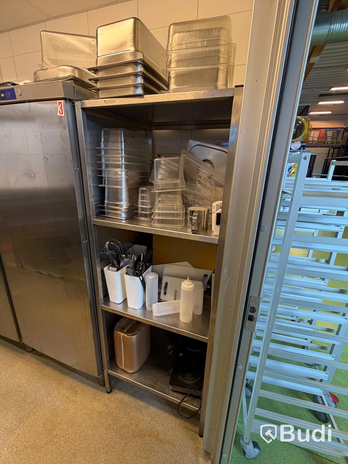 Stainless steel shelving unit with various gastronorm pans and kitchen utensils