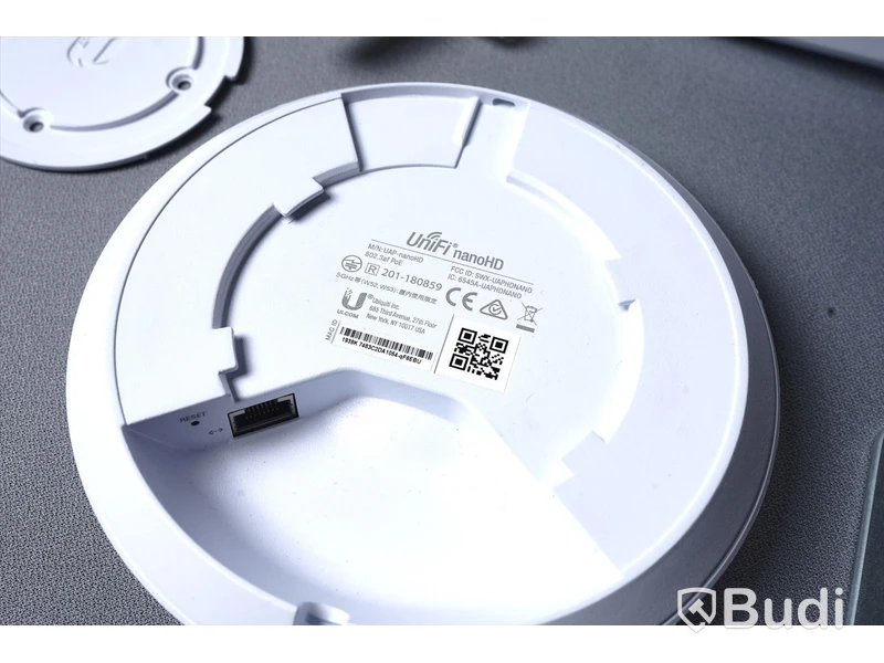Trådlös åtkomstpunkt Ubiquiti UniFi UAP-NanoHD med nätverkskabel, strömförsörjning och takfäste.