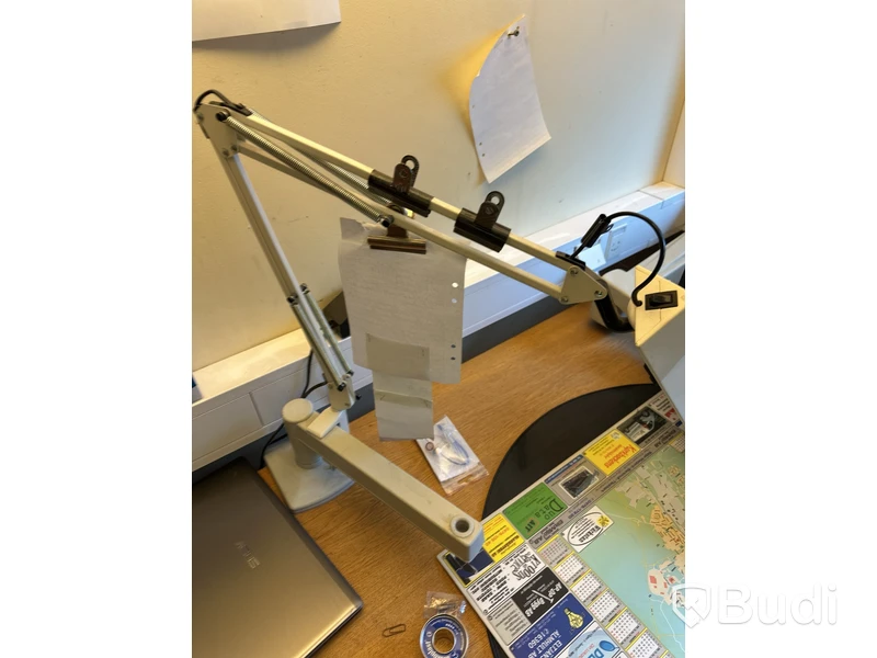 Skrivbord med HP-datorskärm och arbetslampa
