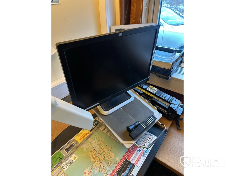 Skrivbord med HP-datorskärm och arbetslampa