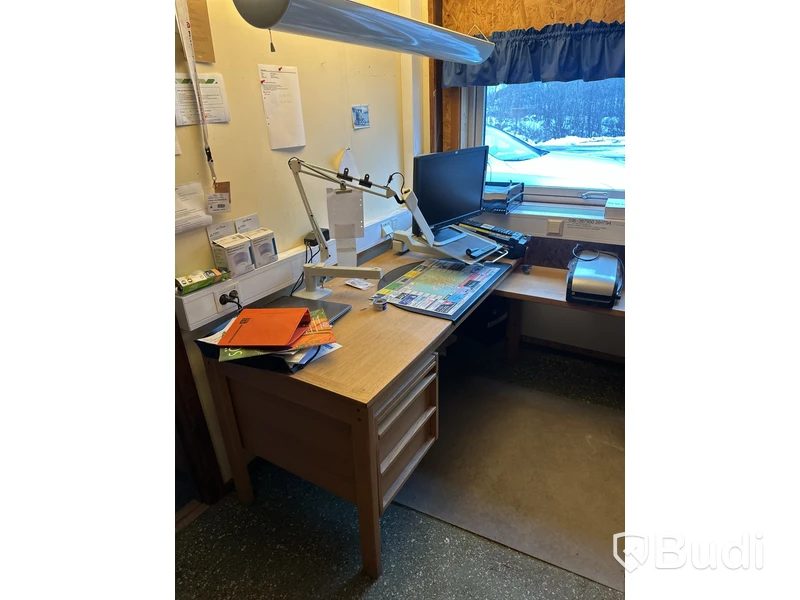 Skrivbord med HP-datorskärm och arbetslampa