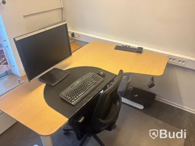 Kontorsplats med skrivbord, stol och skåp.
