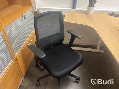 Kontorsplats med skrivbord, stol och skåp.