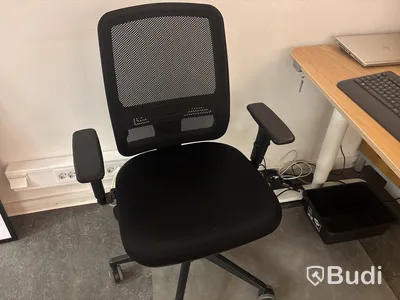 Kontorsplats med skrivbord, stol och skåp.