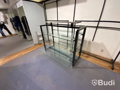 Butikshylla med glashyllor och spjut på hjul