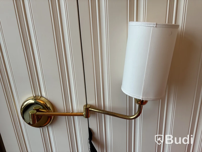 Fåtölj med fotpall, soffbord och vägglampa