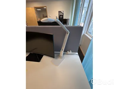 Kontorsplats med höj- och sänkbart skrivbord, kontorsstol och Samsung-skärm