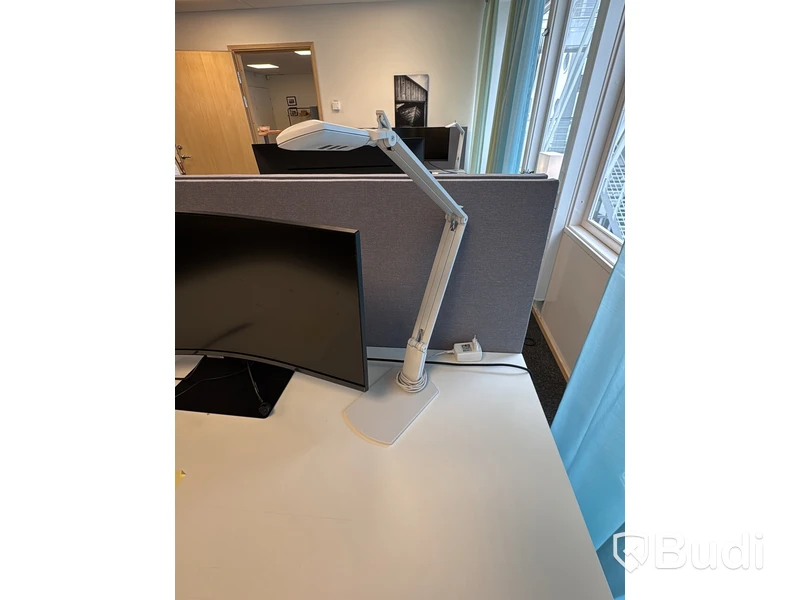 Kontorsplats med höj- och sänkbart skrivbord, kontorsstol och Samsung-skärm