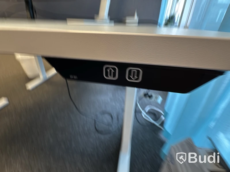Kontorsplats med höj- och sänkbart skrivbord, kontorsstol och Samsung-skärm