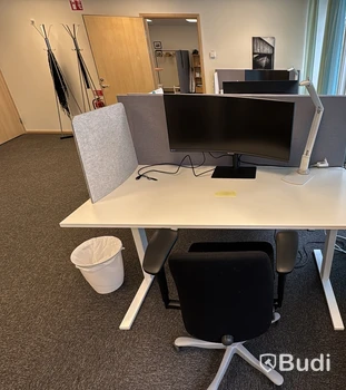 Kontorsplats med höj- och sänkbart skrivbord, kontorsstol och Samsung-skärm