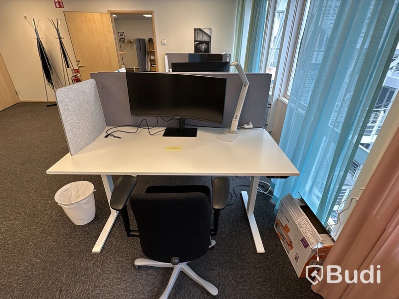 Kontorsplats med höj- och sänkbart skrivbord, kontorsstol och Samsung-skärm