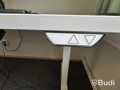 Höj- och sänkbart skrivbord med kontorsstol och Samsung-skärm